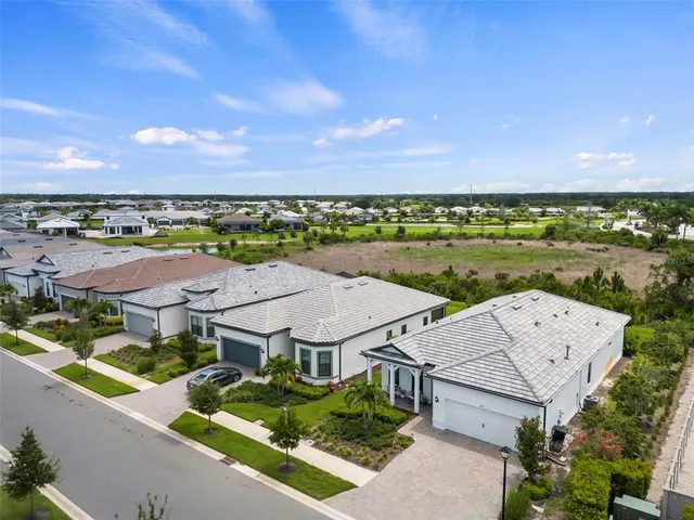 an aerial view of residential houses with outdoor space and swimming pool