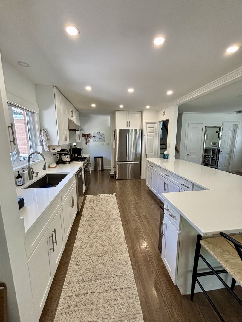 1237 Heatherfield Lane Glenview, IL 60025 - Photo 7 of 33 a large kitchen with stainless steel appliances lots of counter space and wooden floor
