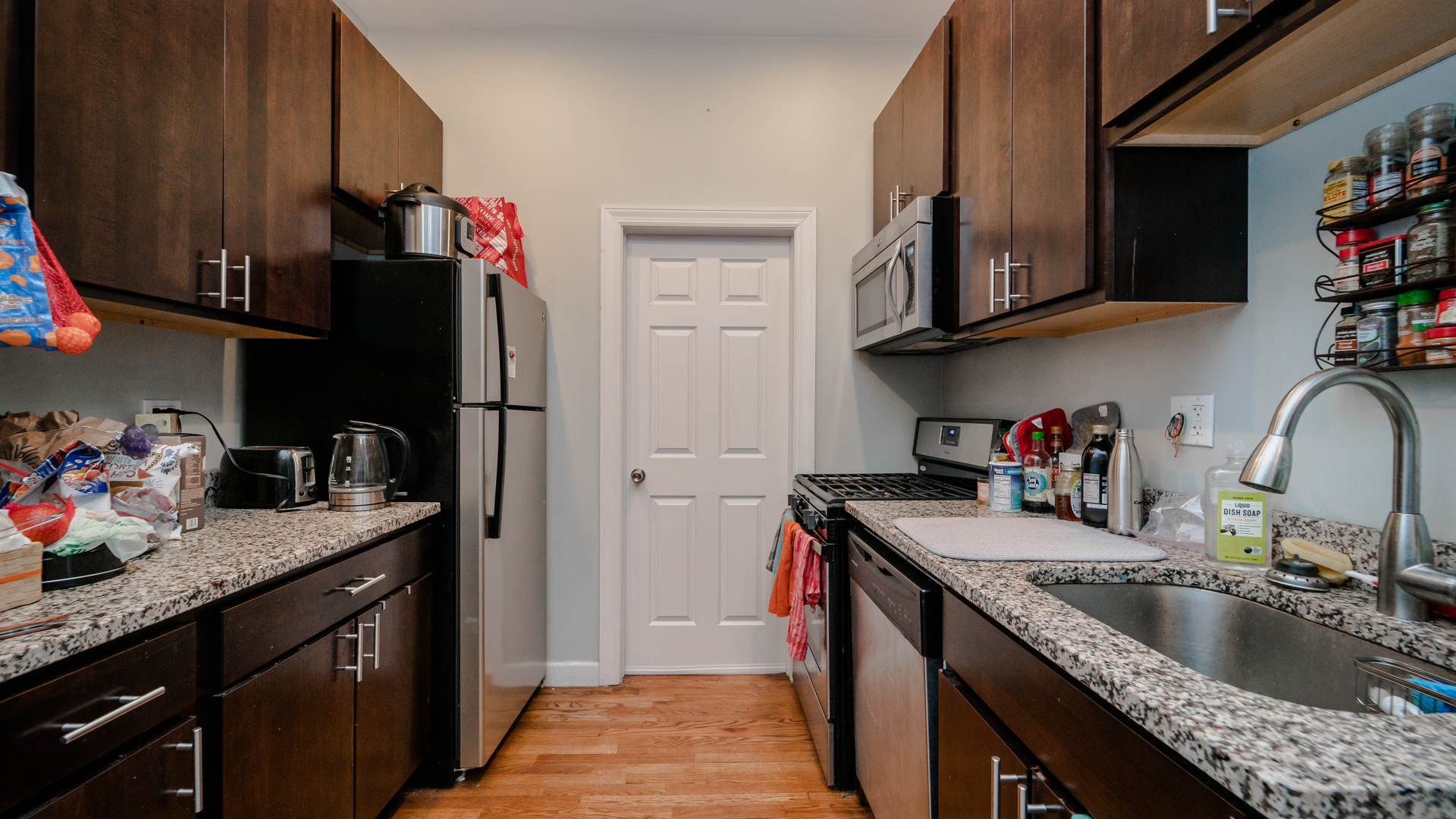656 West Belden Avenue, Unit 202 Chicago, IL 60614 - Photo 6 of 14 a kitchen with granite countertop a sink dishwasher and cabinets with wooden floor