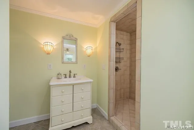 a bathroom with a shower a sink and a mirror