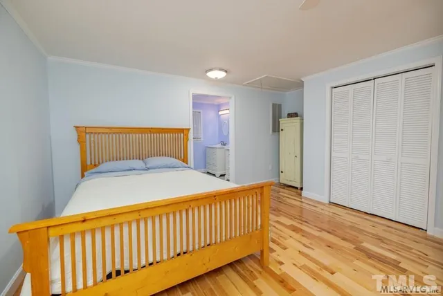 a bedroom with bed and wooden floor