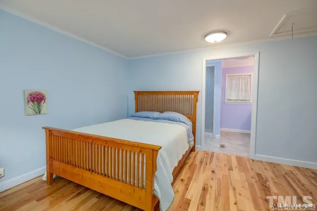 a bedroom with a bed and wooden floor
