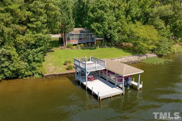 a aerial view of a house with swimming pool garden view and lake view