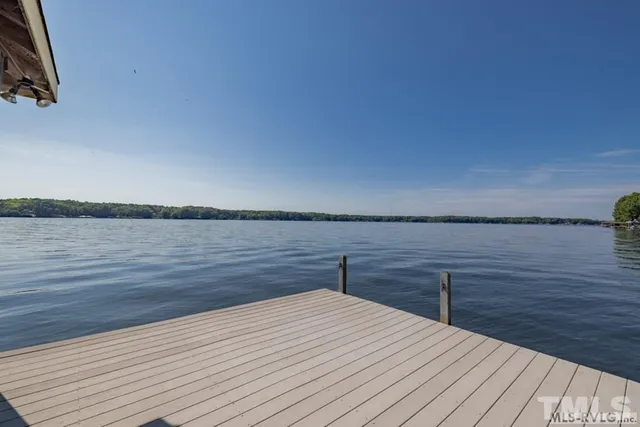 a balcony with wooden floor and lake view