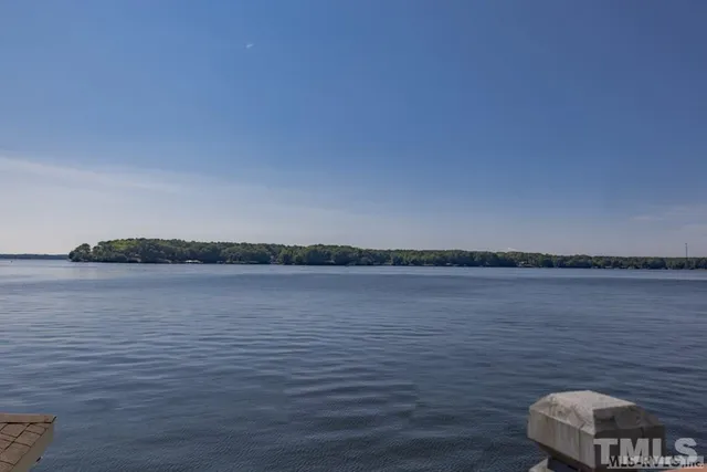 a aerial view of a house with swimming pool a yard and lake view