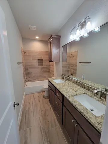 a bathroom with a sink double vanity granite and a shower