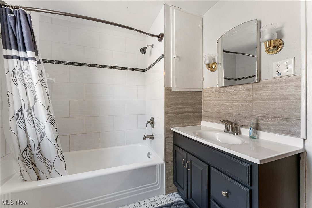 1623 Spangler Road Northeast Canton, OH 44714 - Photo 23 of 28 Full bathroom with shower / bathtub combination with curtain, tile walls, vanity, and light tile patterned floors