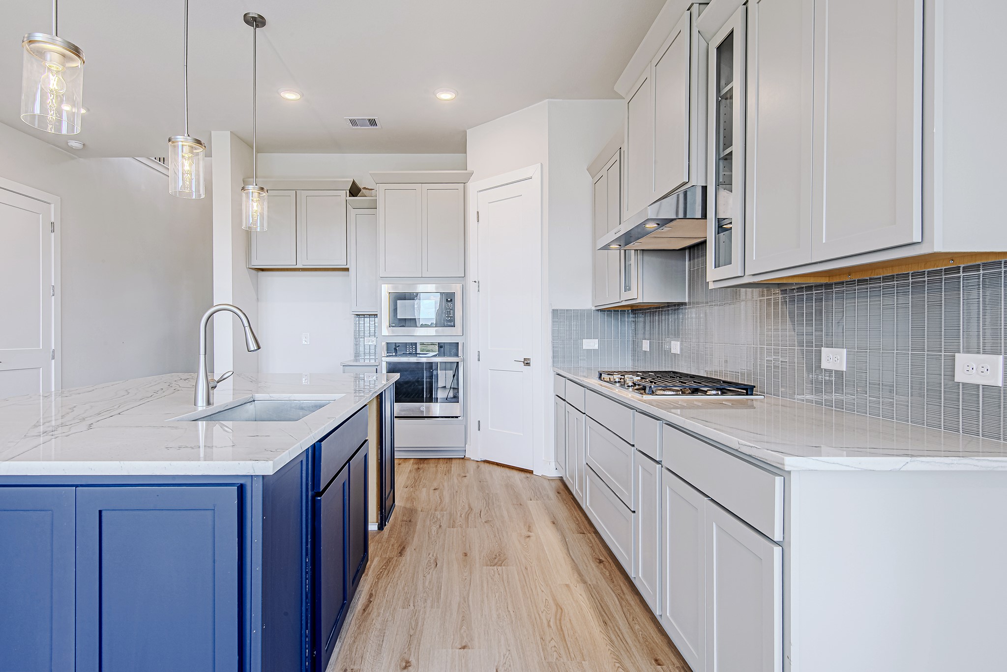 181 Peninsula Point Drive Montgomery, TX 77356 - Photo 11 of 44 A closer look at the kitchen highlights the sleek gas cooktop, built-in microwave and oven, and soft-close drawers designed for everyday ease.