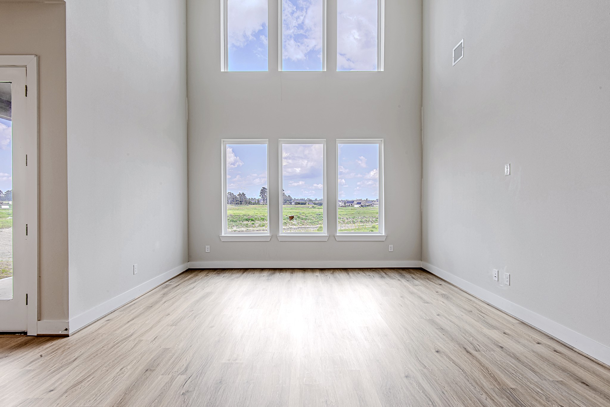 181 Peninsula Point Drive Montgomery, TX 77356 - Photo 14 of 44 Soaring ceilings and a wall of windows flood the living space with natural light, offering peaceful views and an airy, open ambiance.