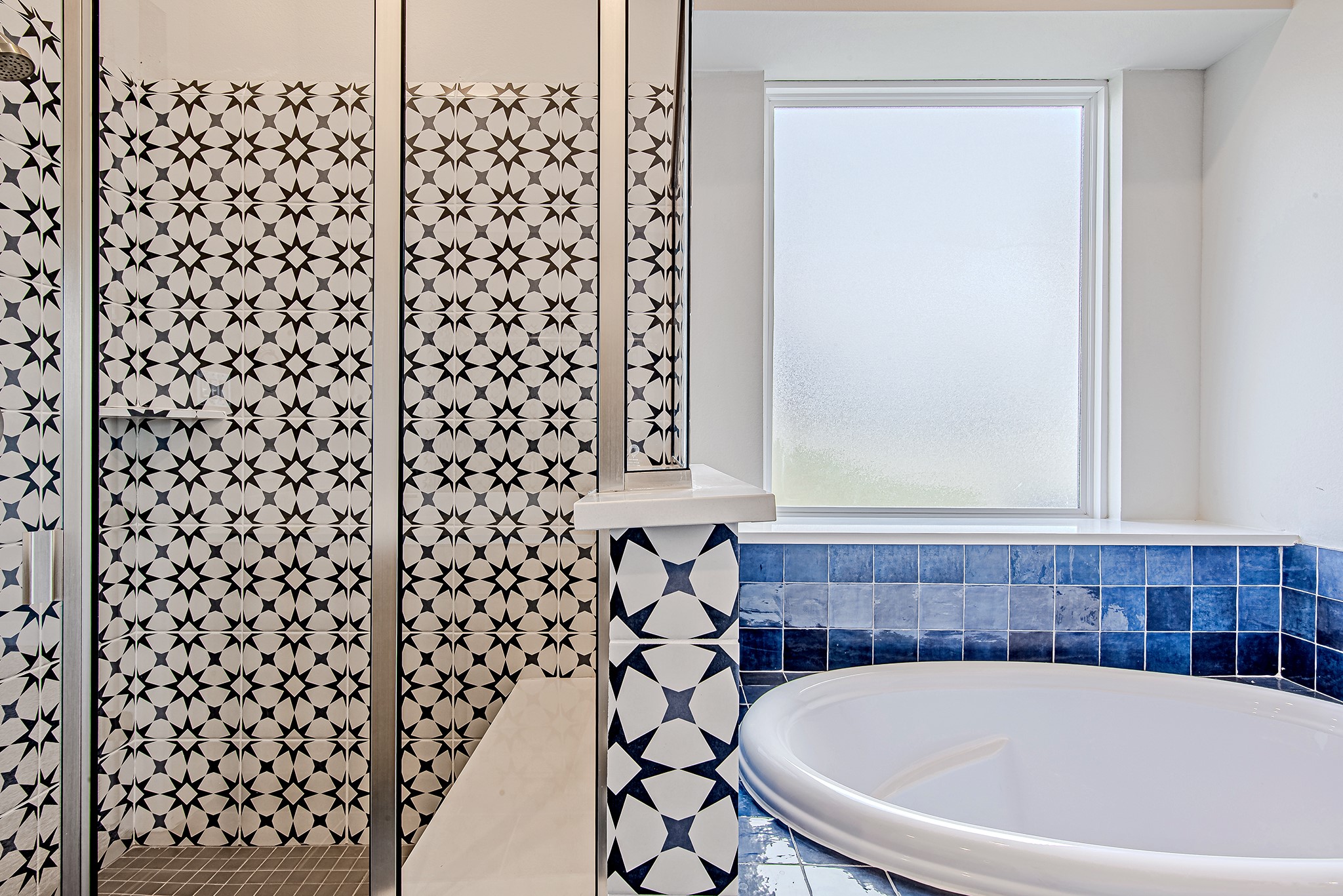 181 Peninsula Point Drive Montgomery, TX 77356 - Photo 20 of 44 The walk-in shower showcases striking geometric tilework that adds bold character, perfectly complemented by a generously sized soaking tub wrapped in rich indigo tile.