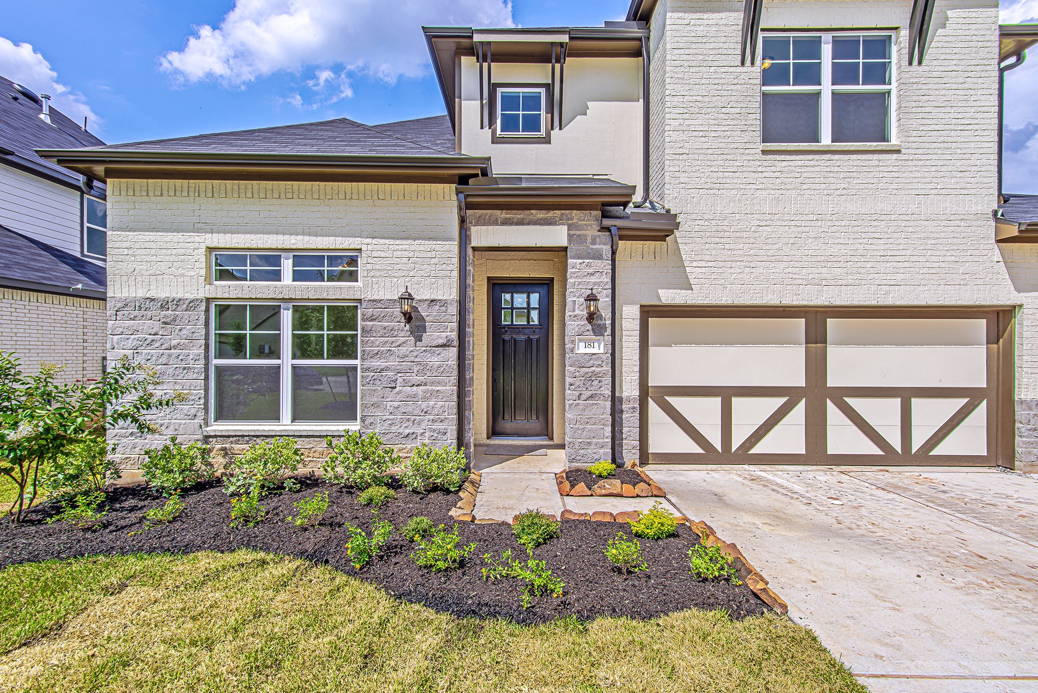 181 Peninsula Point Drive Montgomery, TX 77356 - Photo 5 of 44 A closer look at the inviting entryway, framed by beautiful stone detailing and double coach lights. The front landscaping is freshly mulched and thoughtfully arranged for an easy-maintenance, polished look.