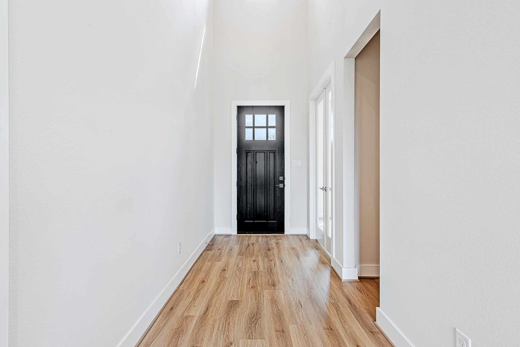 181 Peninsula Point Drive Montgomery, TX 77356 - Photo 7 of 44 This alternate perspective of the foyer highlights the sleek black front door, flanked by double glass-paned French doors—ideal for a home office or study. The clean, neutral palette offers a bright and airy first impression.