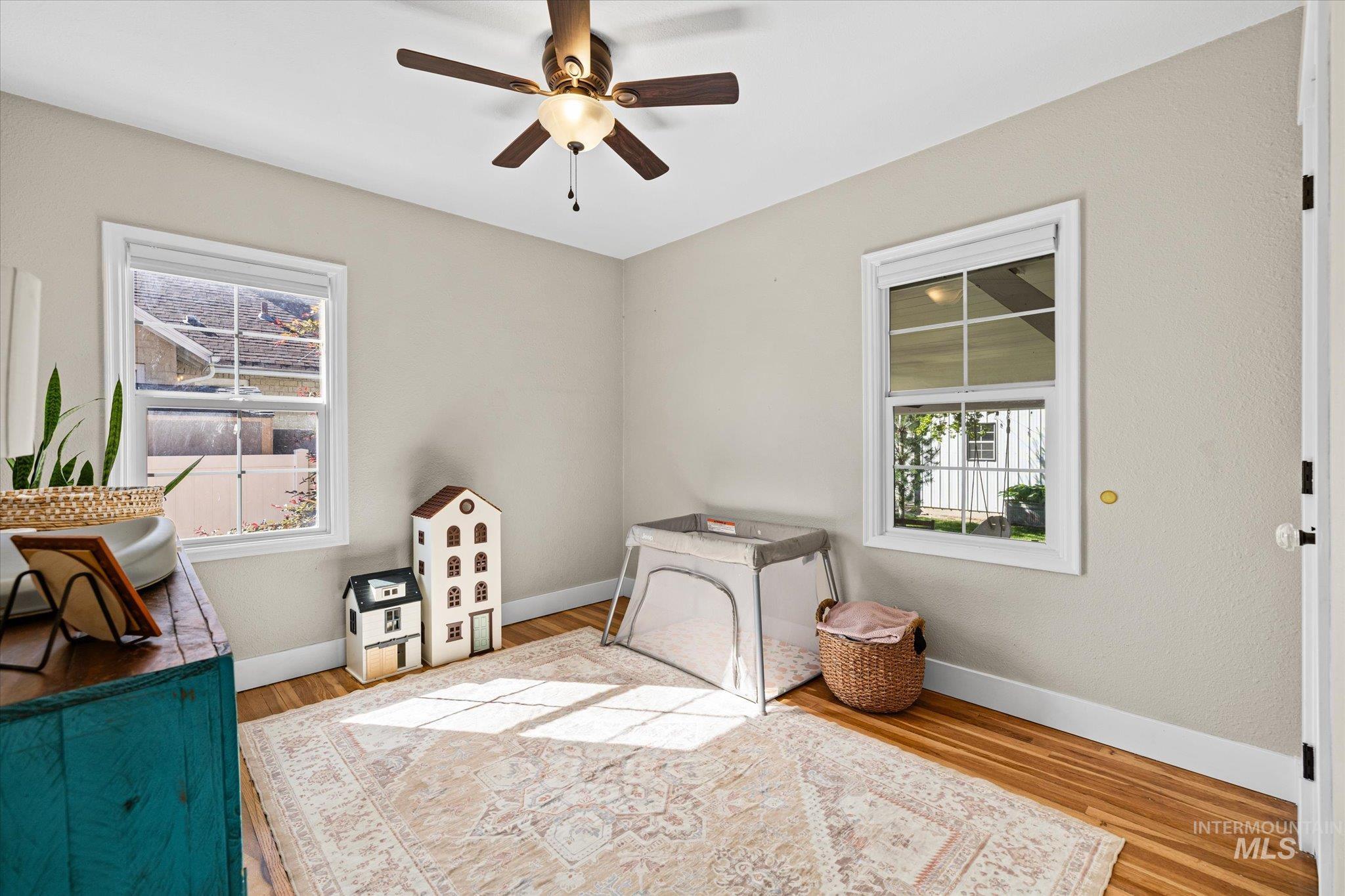 1008 Fillmore Street Caldwell, ID 83605 - Photo 20 of 50 Bedroom featuring multiple windows, light wood-style floors, and ceiling fan