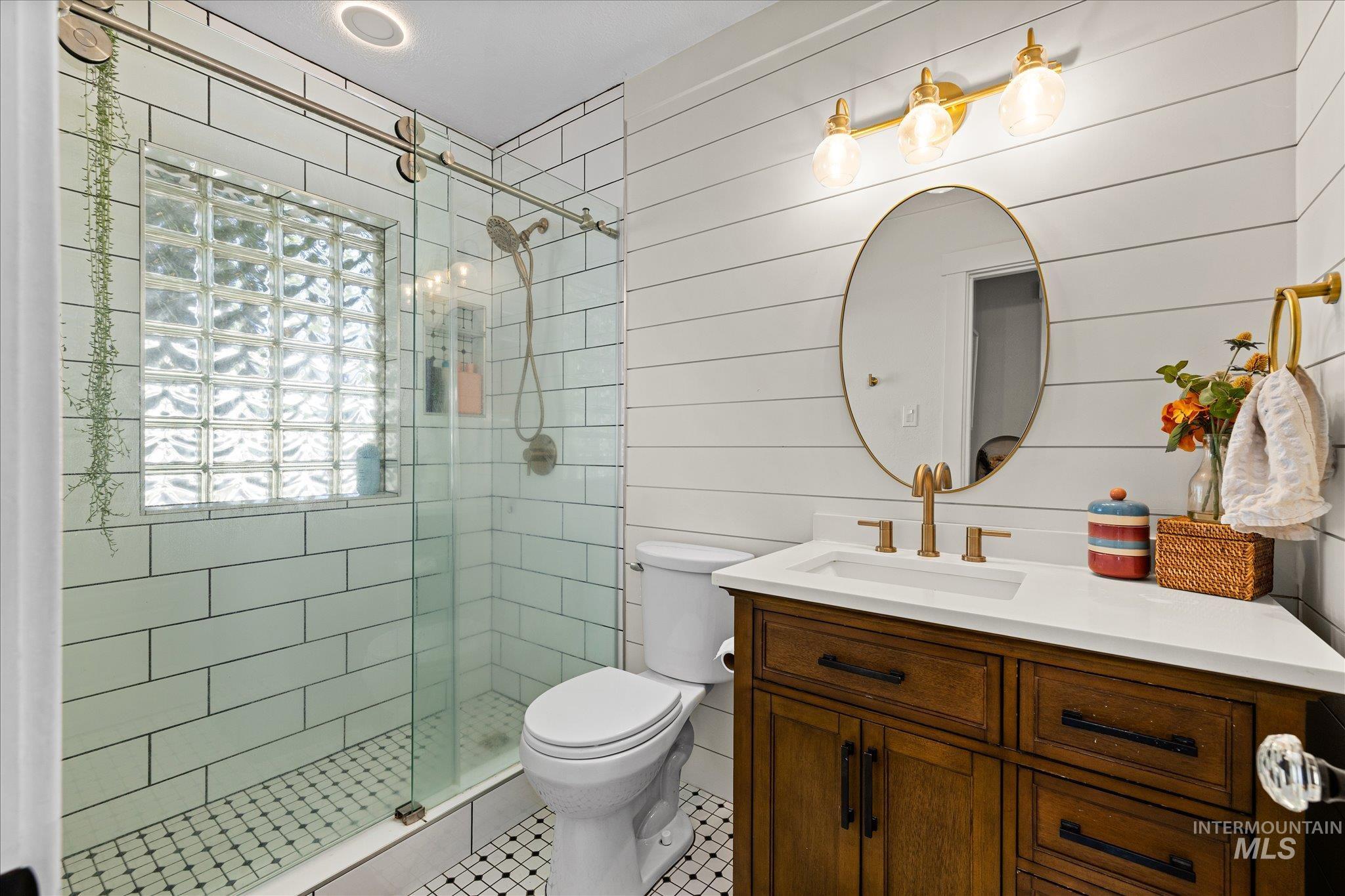 1008 Fillmore Street Caldwell, ID 83605 - Photo 32 of 50 Full bathroom with vanity, wooden walls, a shower stall, and light tile patterned floors