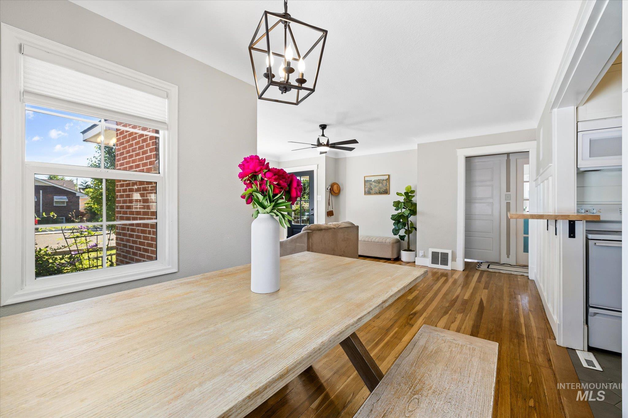1008 Fillmore Street Caldwell, ID 83605 - Photo 42 of 50 Unfurnished dining area featuring wood-type flooring, plenty of natural light, a ceiling fan, and a chandelier