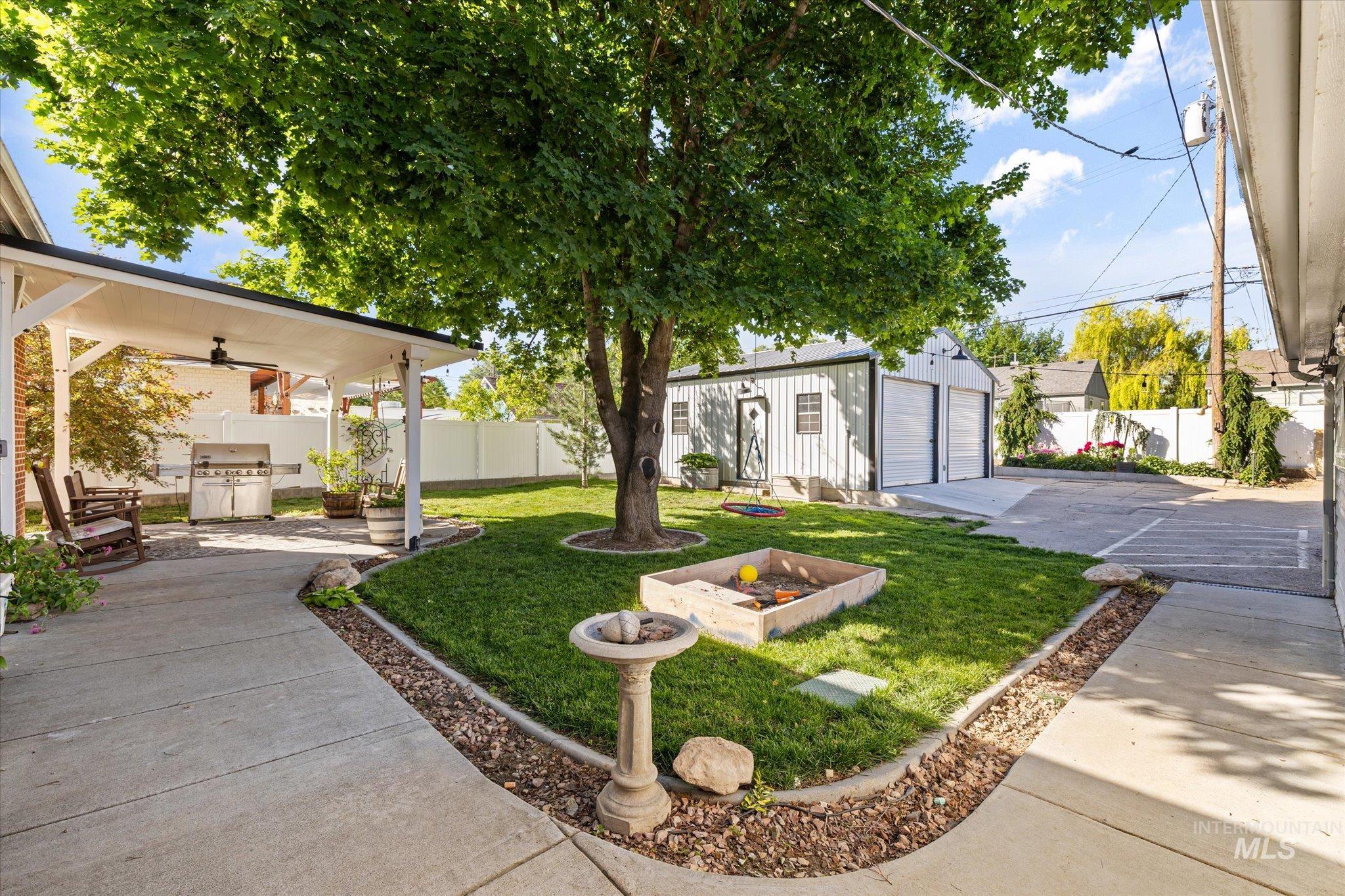 1008 Fillmore Street Caldwell, ID 83605 - Photo 6 of 50 Fenced backyard with an outdoor structure, an outdoor fire pit, a patio area, a garage, and ceiling fan