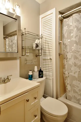 a bathroom with a sink a mirror a toilet and shower