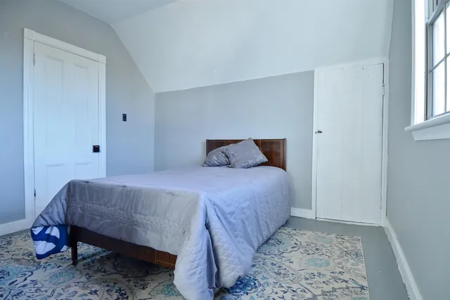 a bedroom with a bed and a window