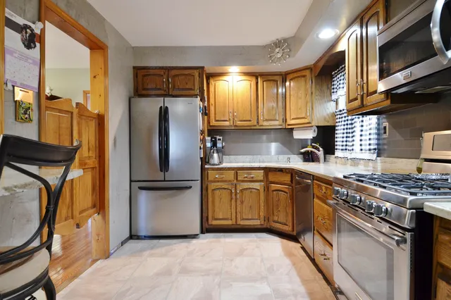 a kitchen with stainless steel appliances granite countertop a stove a refrigerator and a sink