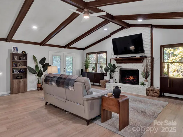 a living room with furniture a flat screen tv and a fireplace