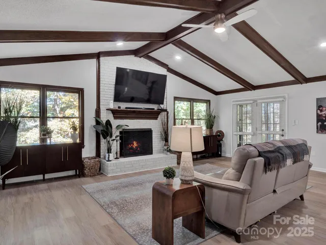 a living room with furniture a fireplace and a flat screen tv