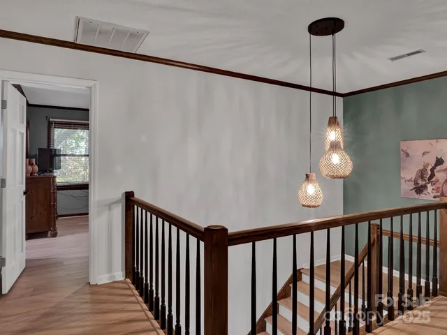 a view of a hallway with wooden floor and staircase