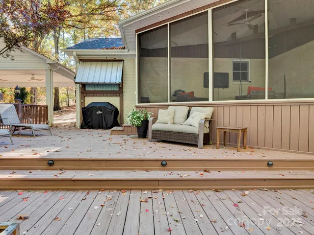 a roof deck view with table and chairs and wooden floor