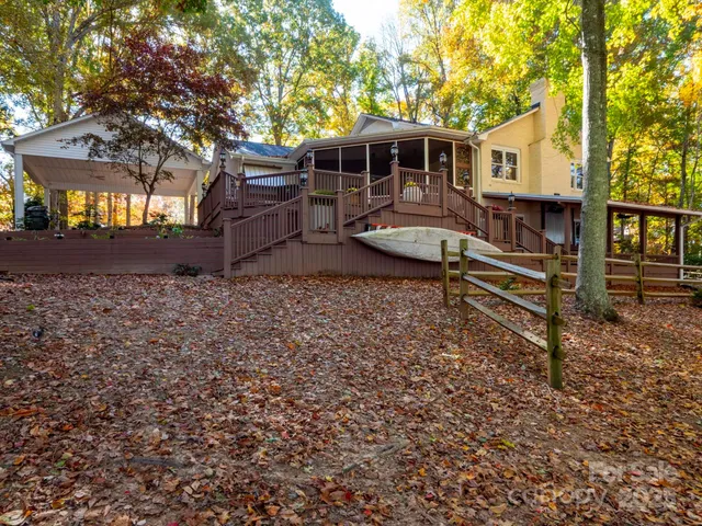 a view of a house with backyard and wooden fence