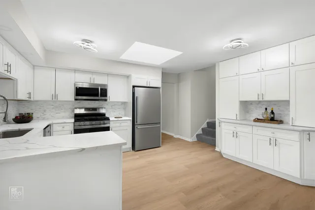 a kitchen with stainless steel appliances a refrigerator stove microwave and sink