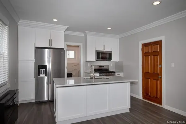 a kitchen with stainless steel appliances a refrigerator sink and microwave