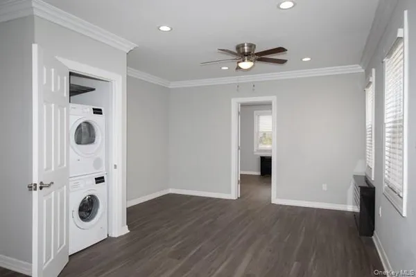 a view of a hallway with wooden floor and a ceiling fan