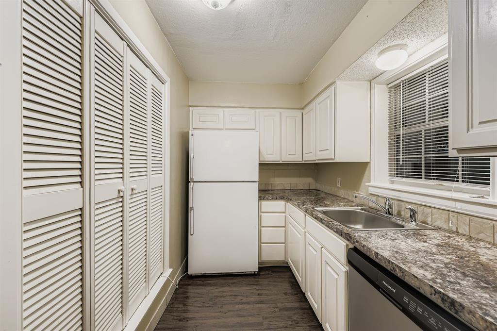 214 Austin Street Grapevine, TX 76051 - Photo 11 of 28 a kitchen with a sink and a refrigerator