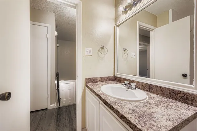 a bathroom with a granite countertop sink and a mirror