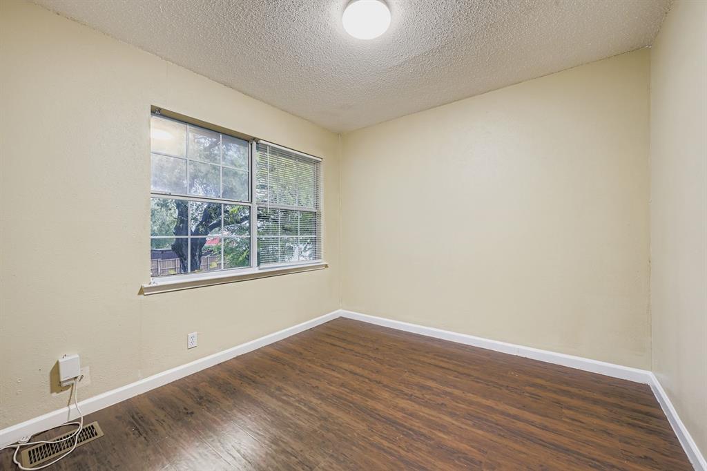 214 Austin Street Grapevine, TX 76051 - Photo 19 of 28 a view of an empty room with wooden floor and a window