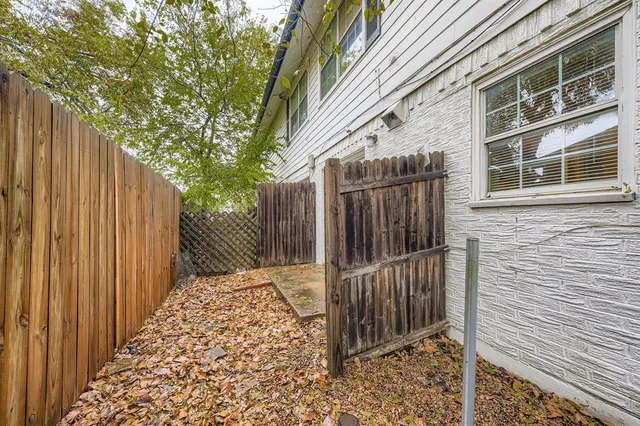 a view of a pathway of a house with wooden fence