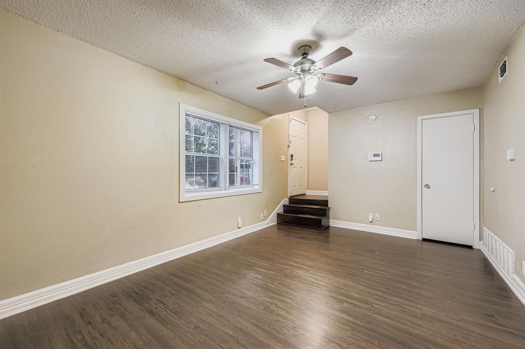 214 Austin Street Grapevine, TX 76051 - Photo 5 of 28 a view of an empty room with wooden floor and a window