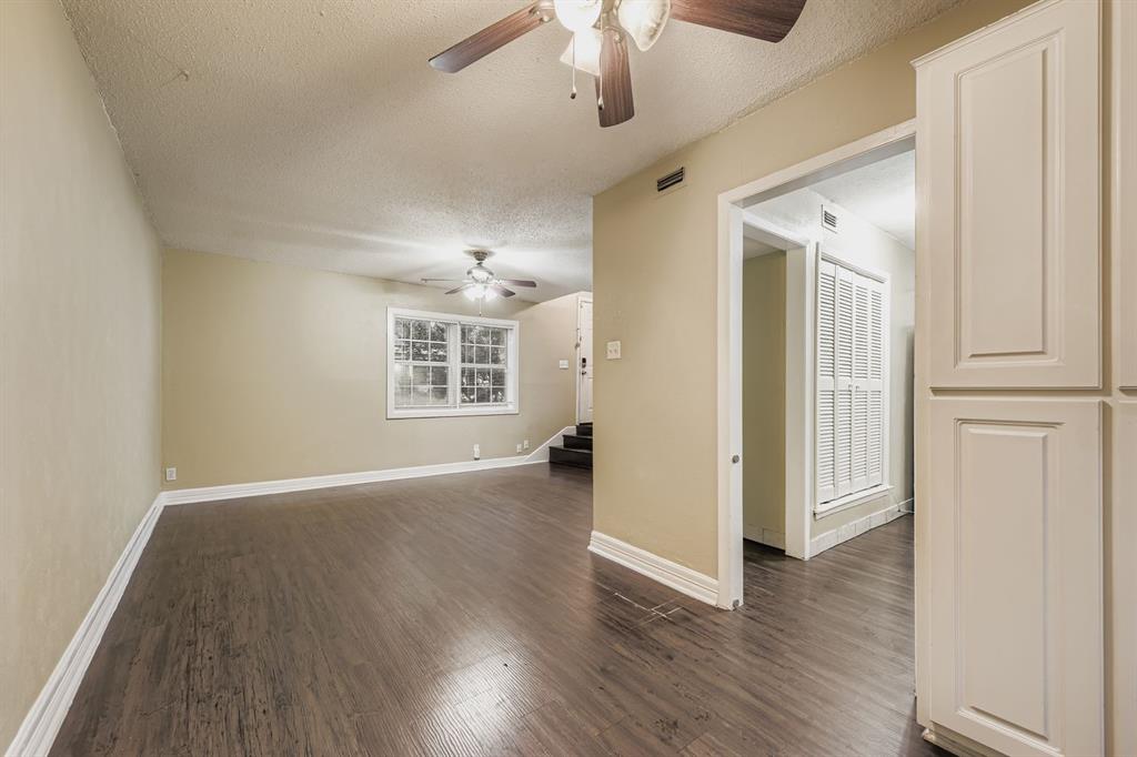 214 Austin Street Grapevine, TX 76051 - Photo 7 of 28 an empty room with wooden floor cabinet and windows