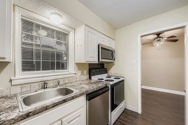 a kitchen with granite countertop a sink and a stove top oven