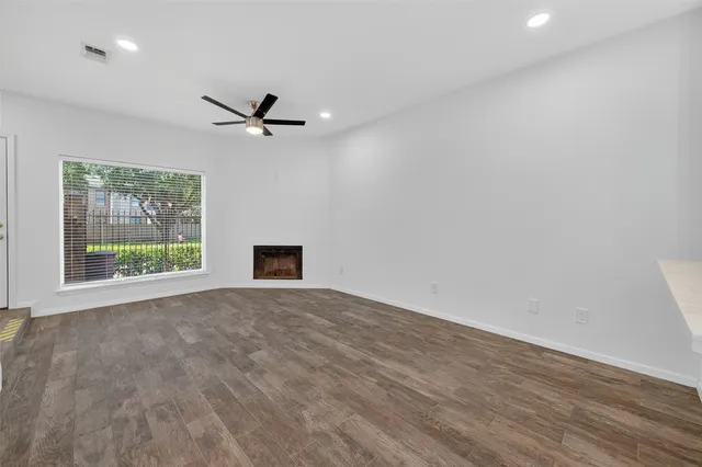 an empty room with a window and a ceiling fan