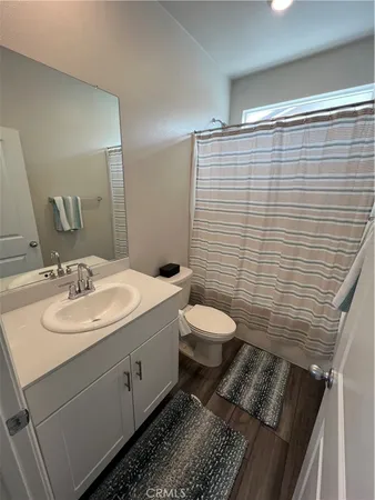 a bathroom with a granite countertop toilet sink and mirror