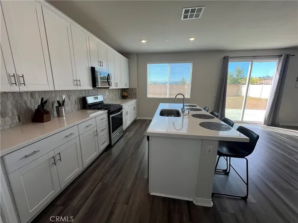 a kitchen with sink cabinets and wooden floor