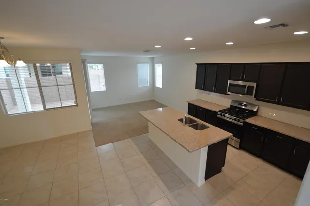 a living room with stainless steel appliances kitchen island granite countertop furniture and a view of kitchen