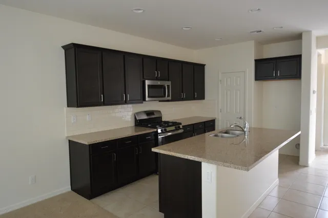 a kitchen with a sink and a stove top oven with wooden floor