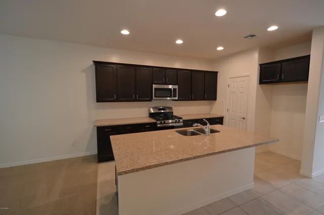 a kitchen with a sink a microwave a stove and refrigerator