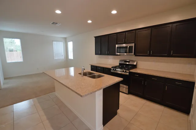 a kitchen with a sink and a stove top oven with wooden floor