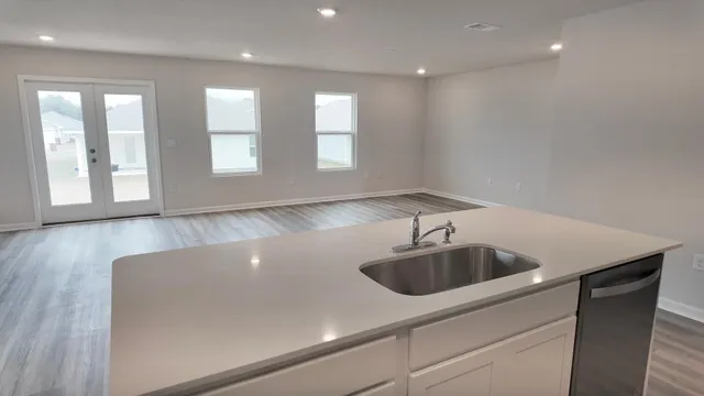 a kitchen with a sink cabinets and wooden floor