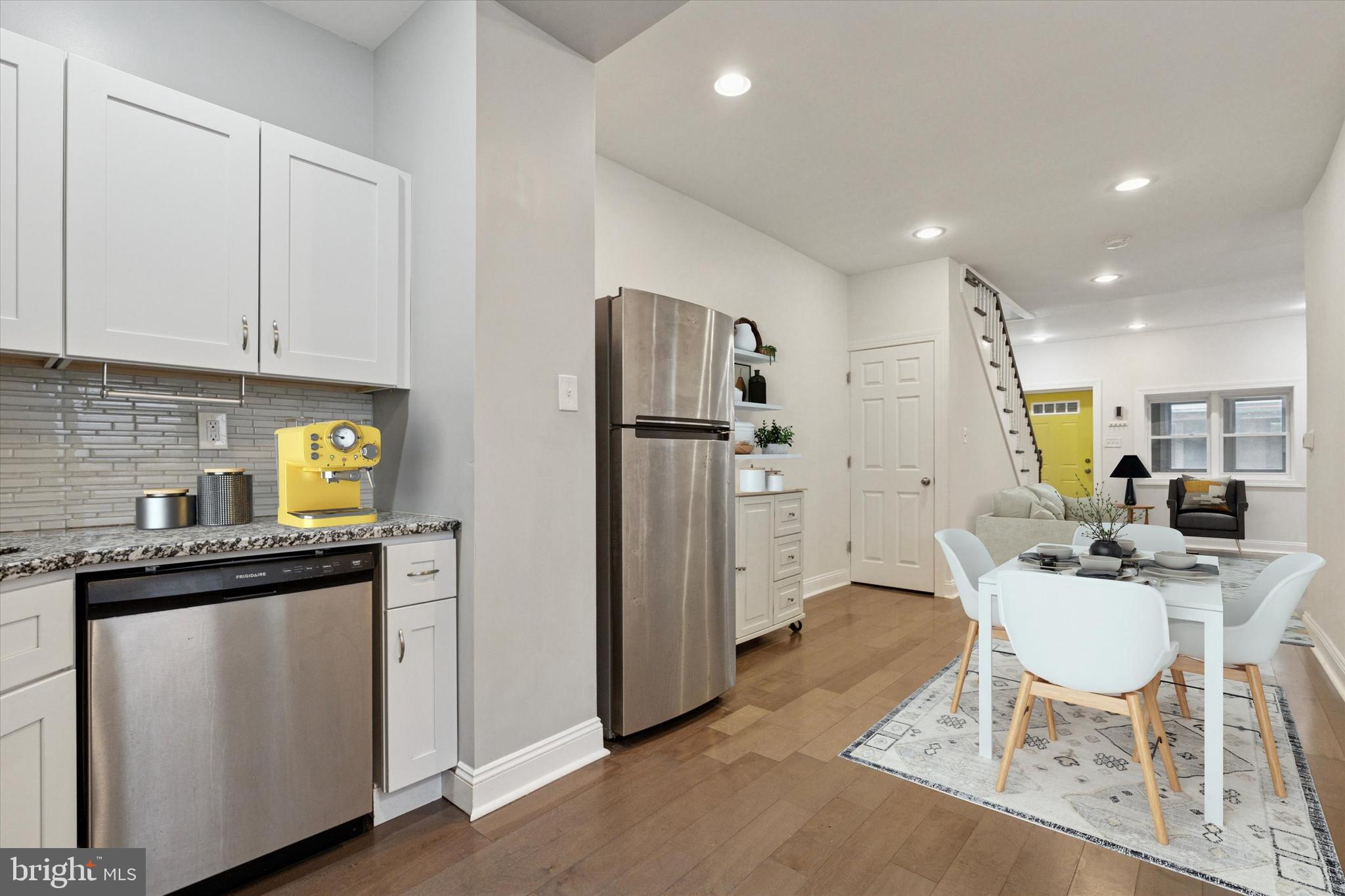 5121 Hadfield Street Philadelphia, PA 19143 - Photo 5 of 19 a kitchen with stainless steel appliances granite countertop a refrigerator a sink a stove a dining table and chairs