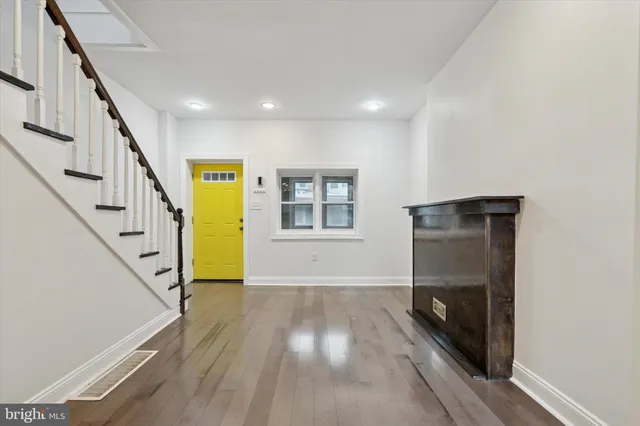 a view of a hallway with wooden floor and staircase