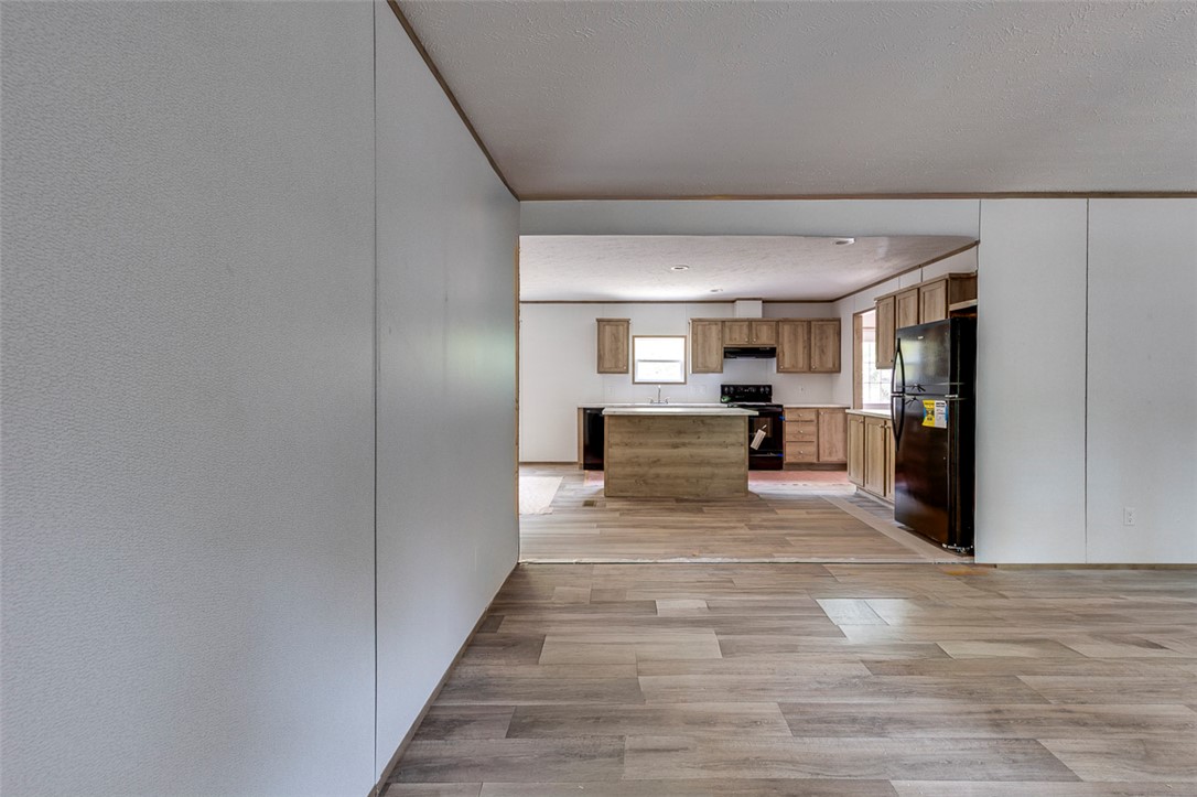 474 Bryant Road Pelzer, SC 29669 - Photo 12 of 42 Wood-look flooring leads to a kitchen featuring an island and ample cabinetry.
