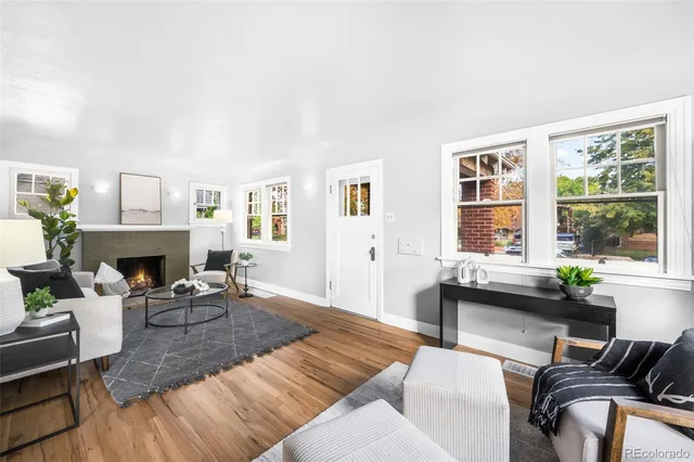 a living room with furniture a fireplace and a large window